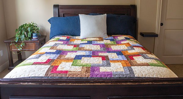 Linen Stories Quilt on a Bed