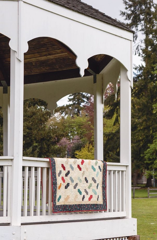 Charming Wonder Bow Tie Quilt shown on a porch