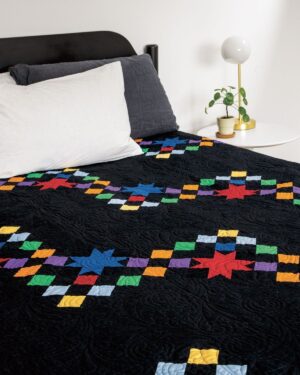 Galaxy-of-stars-quilt on a bed