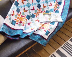 Aries Throw Quilt on a couch