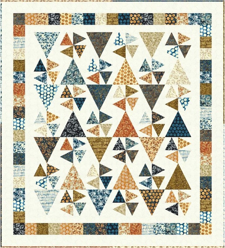 A Confetti Quilt Pattern featuring a geometric array of multicolored triangles—blue, orange, gold, beige, and cream—arranged in a playful, scattered design with a border of small rectangles in matching hues.