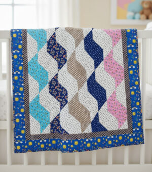 A colorful Strolling Geese Quilt Pattern featuring zigzag designs in blue, aqua, brown, pink, and white, bordered by blue fabric with yellow flowers, draped over a white crib in a softly lit room.