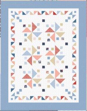A colorful quilt with a blue border, featuring a pattern of large triangles in shades of blue, red, tan, and white, and scattered small square patches with various prints on a white background.