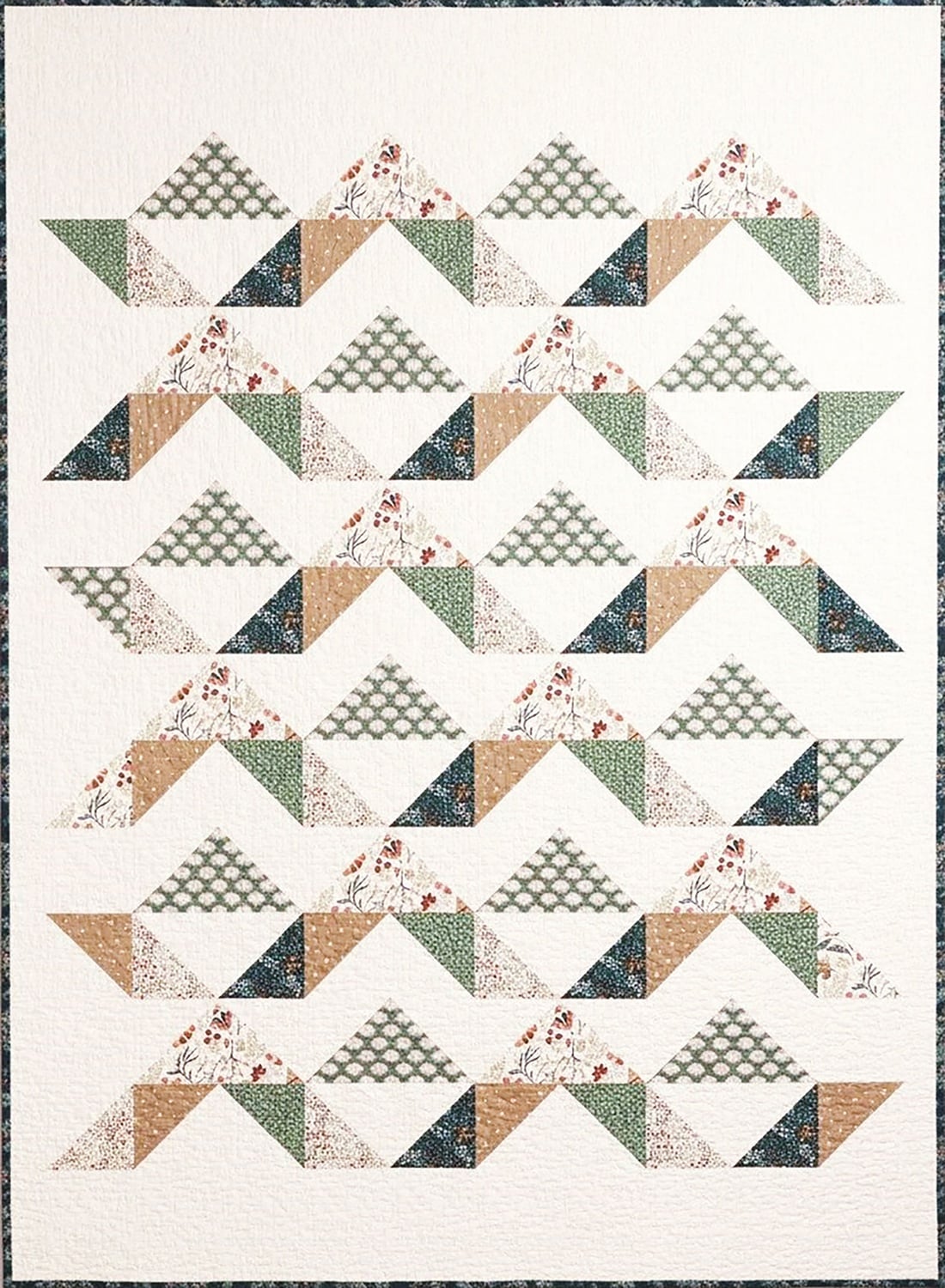 Briar-Ridge Quilt with rows of geometric patterns in earthy green, beige, and brown tones, featuring triangles and squares with floral and checkered prints on a white background.