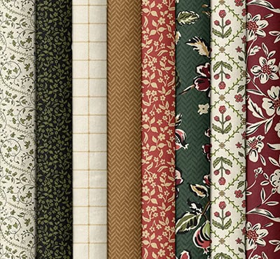 Eight fabrics used in the Cider and Cloves quilt in cream, black, caramel, garnet, and dark green prints